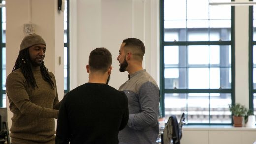 a group of men standing around each other in a room